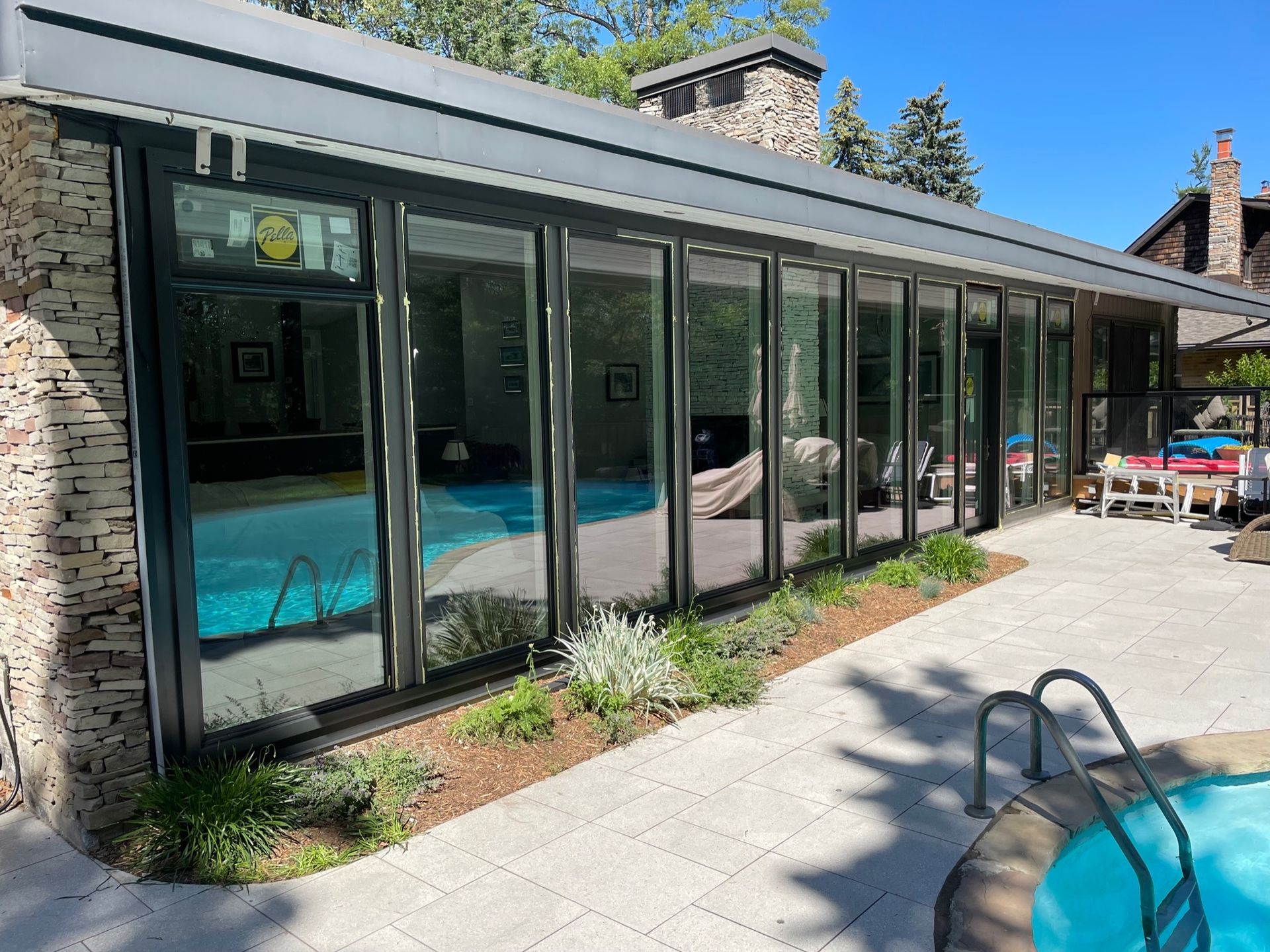 Poolside structure with large glass doors, stone facade, and pool visible.