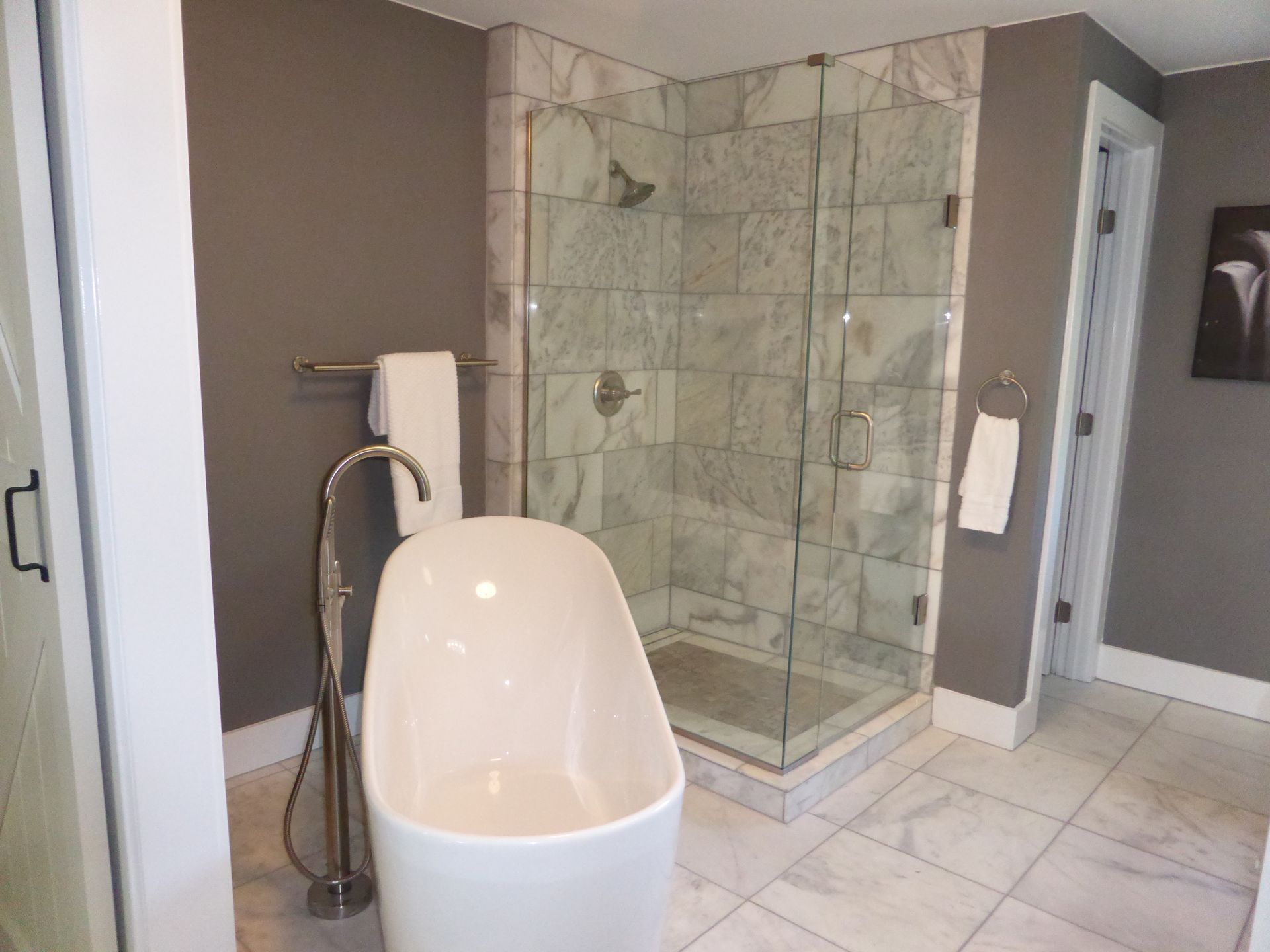 Modern bathroom with freestanding tub, glass shower, and tile floor