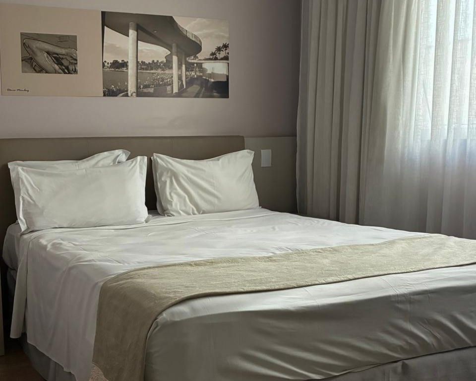Cama impecavelmente arrumada em um quarto de hotel
