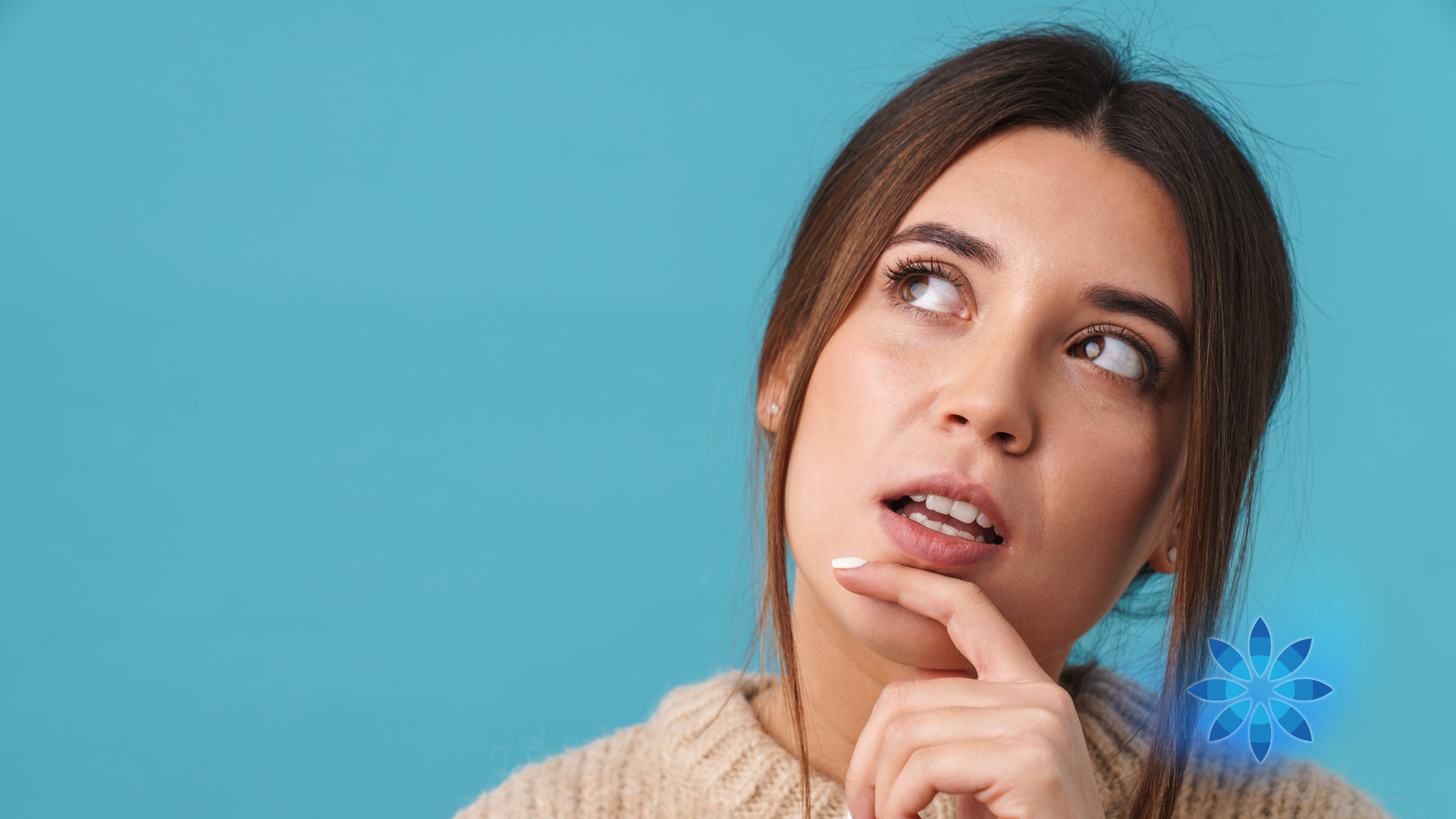 Thoughtful woman looking up with hand on chin against a blue background