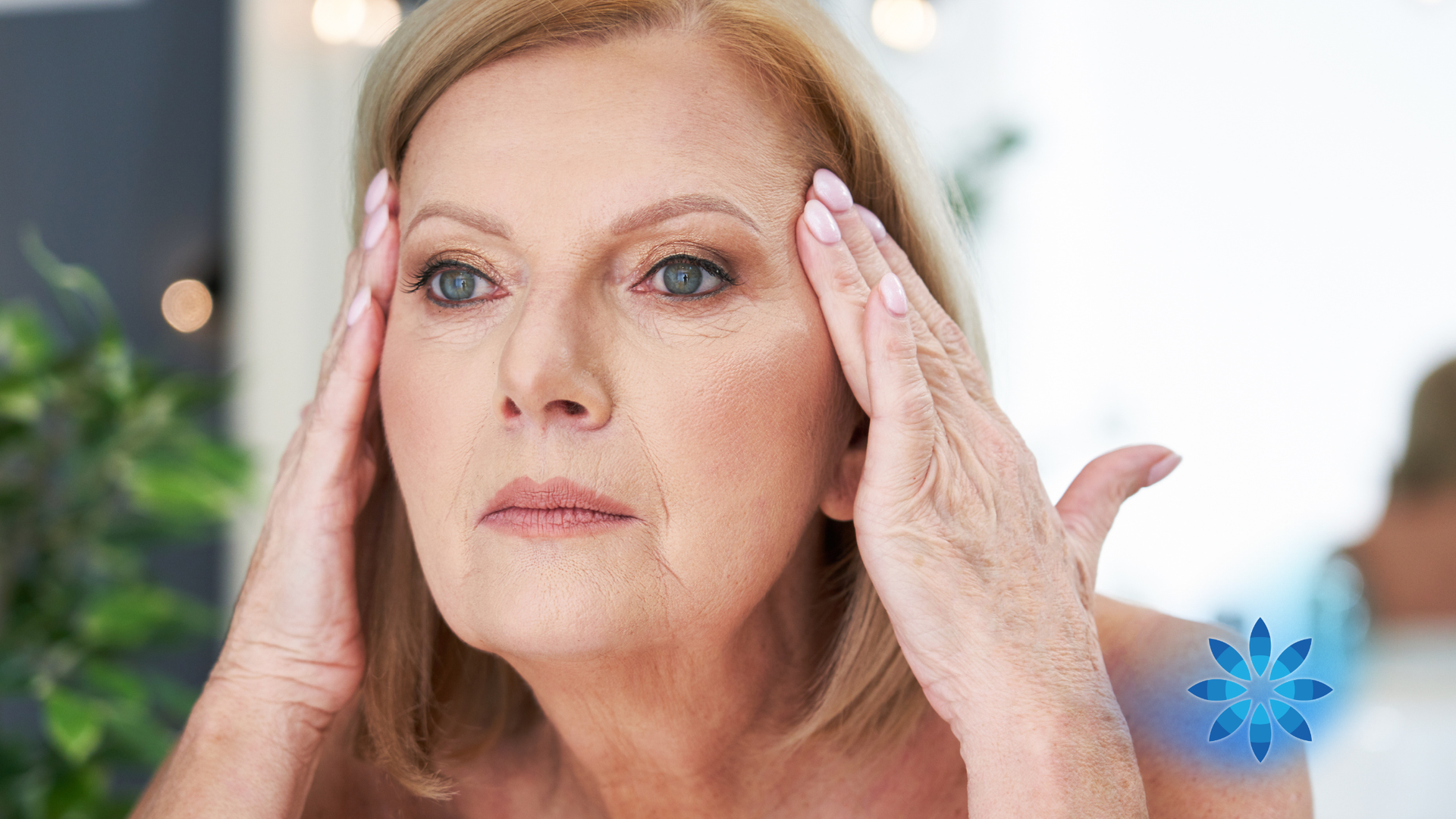 Woman touching her face, looking in mirror.