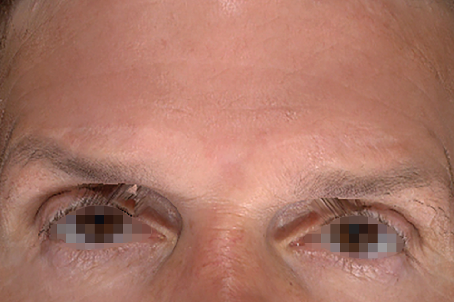 Close-up of a person’s eyes and eyebrows on a light background