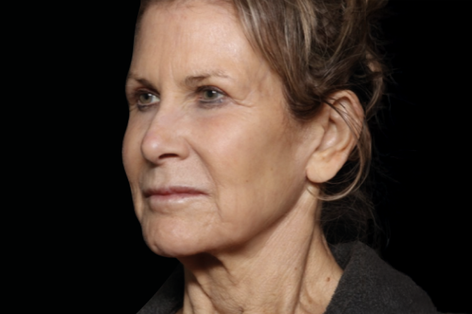 Portrait of a woman with a neutral expression against a dark background