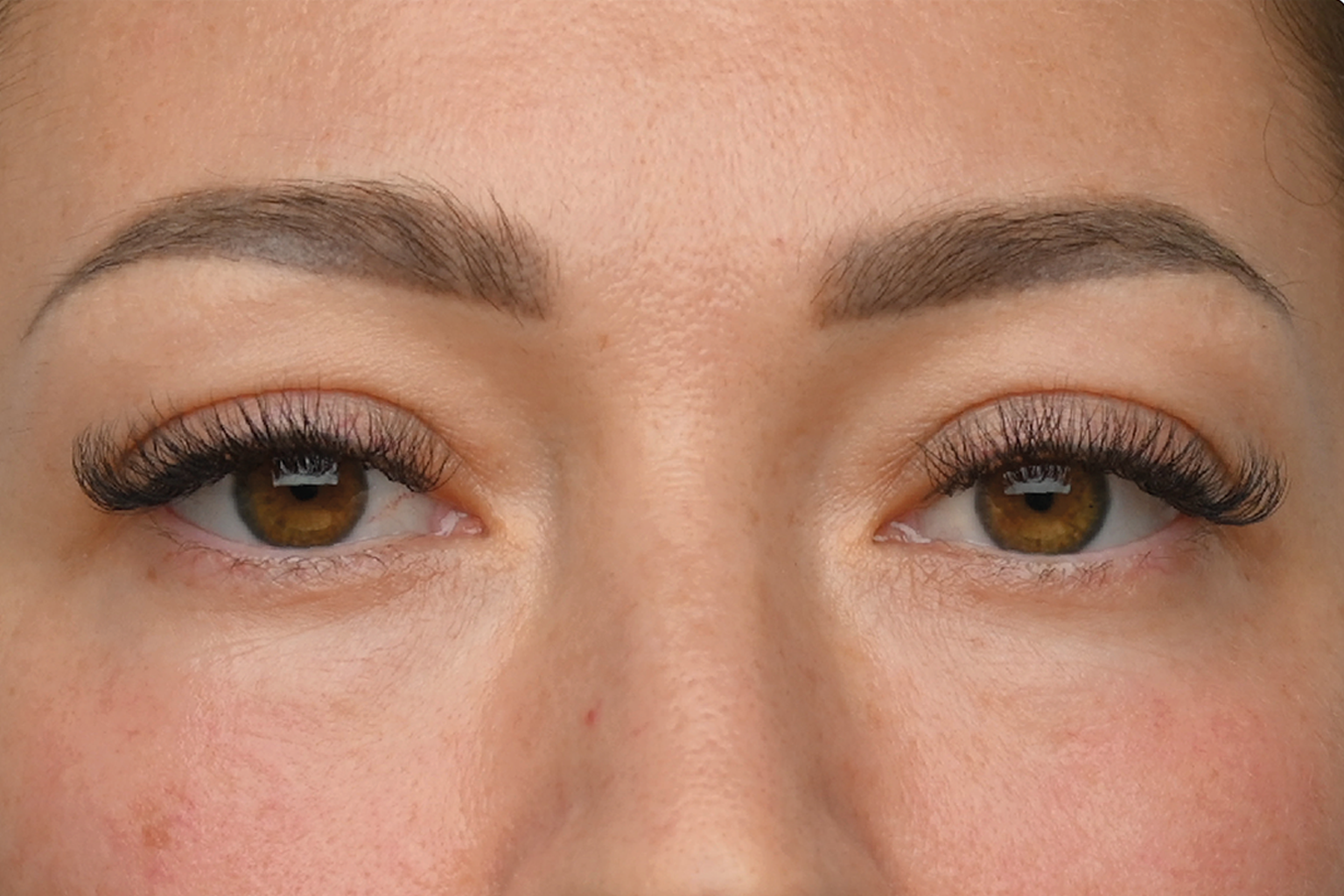 Close-up of brown eyes with long eyelashes and groomed eyebrows