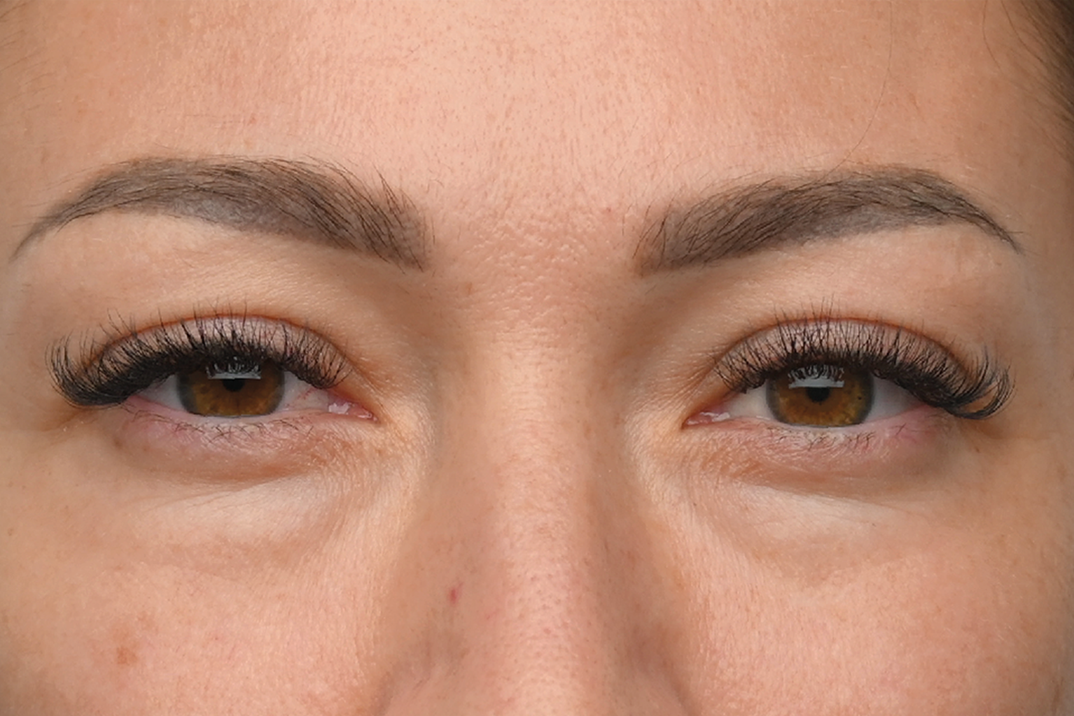 Close-up of a person's eyes with eyeliner and mascara, looking straight ahead