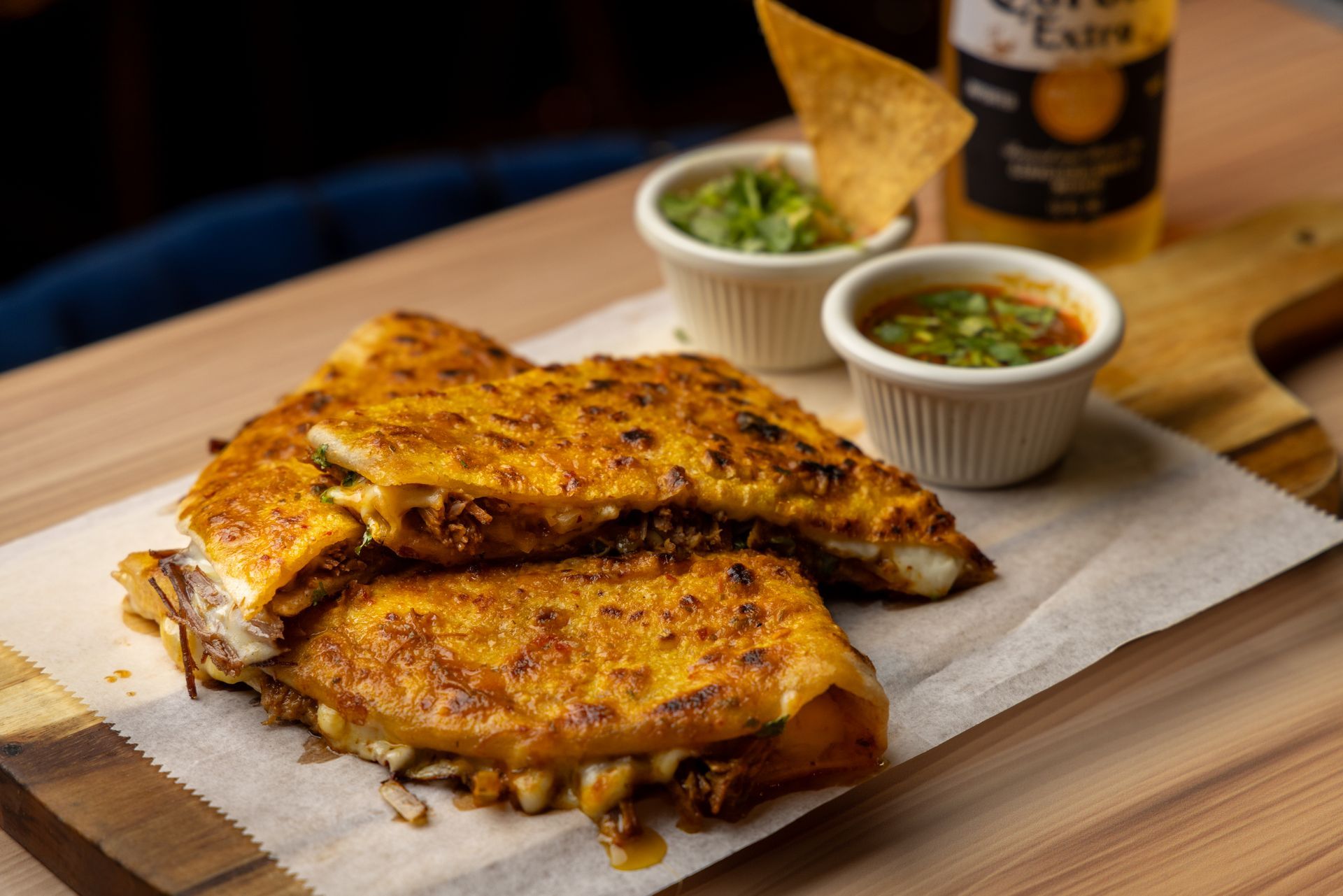 Quesadilla with guacamole, salsa, tortilla chips, and Corona beer.