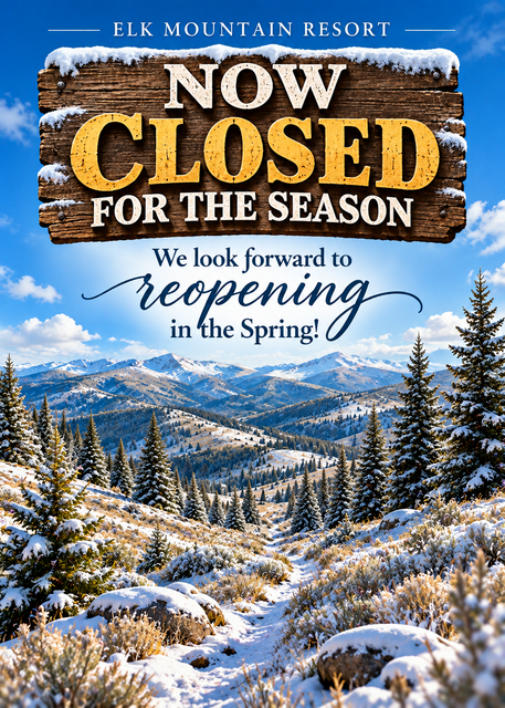 ELK Mountain Resort sign says “Now Closed for the Season” over a colorful spring mountain landscape