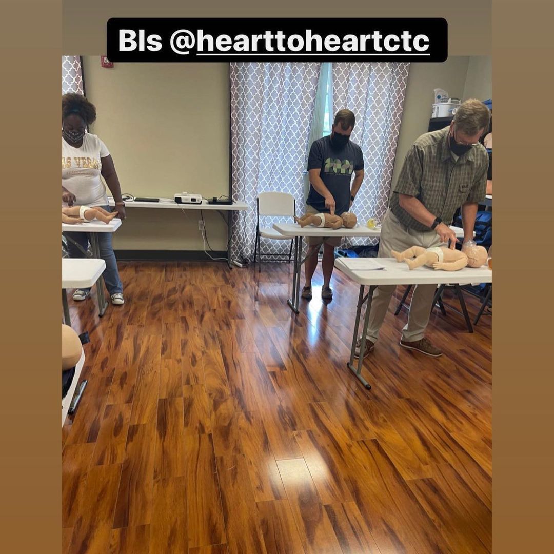 People practicing CPR on baby mannequins at a training course.