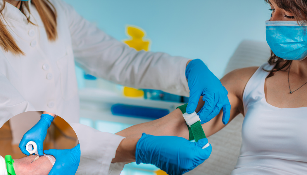 Medical professional drawing blood from a patient's arm. The patient wears a mask.