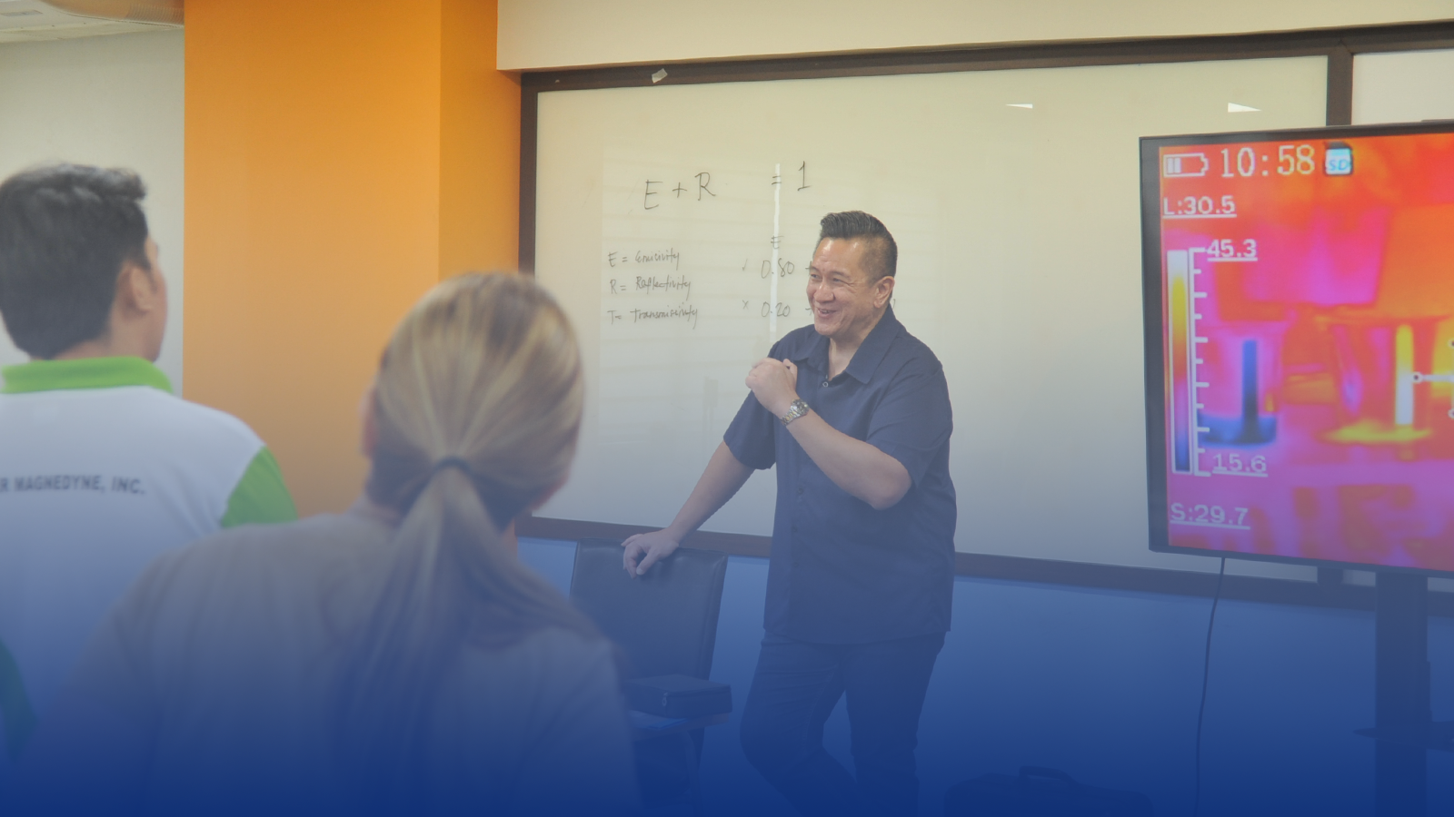 A man is giving a presentation in front of a group of people in a classroom.