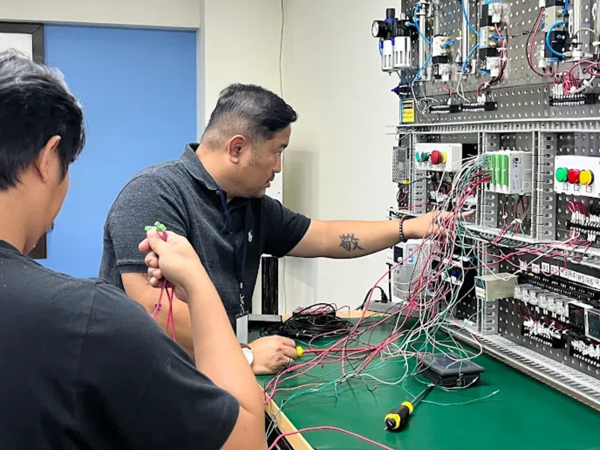 A close up of a person working on a electrical panel.