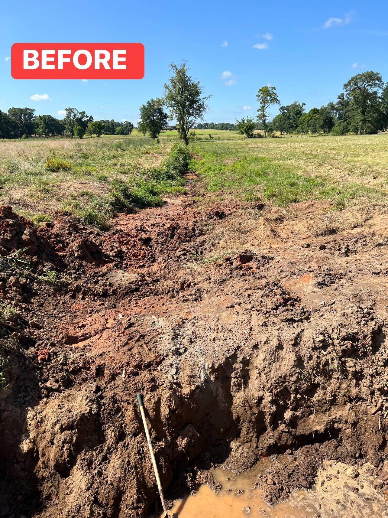 A dirt trench dug in a field. 