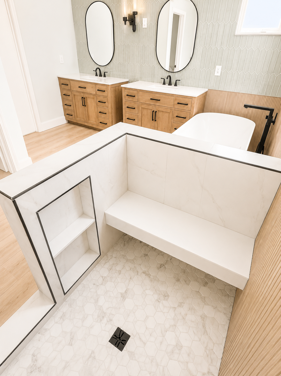 Modern bathroom with a walk-in shower, white bench, double vanity, and light wood cabinetry