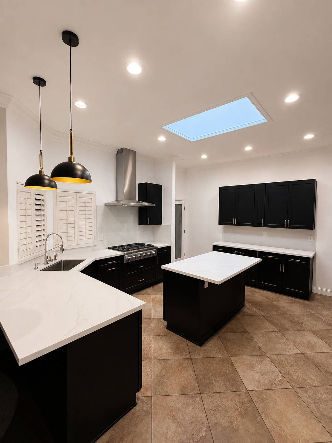 Modern kitchen with white countertops, black cabinets, pendant lights, and a skylight on tiled floor