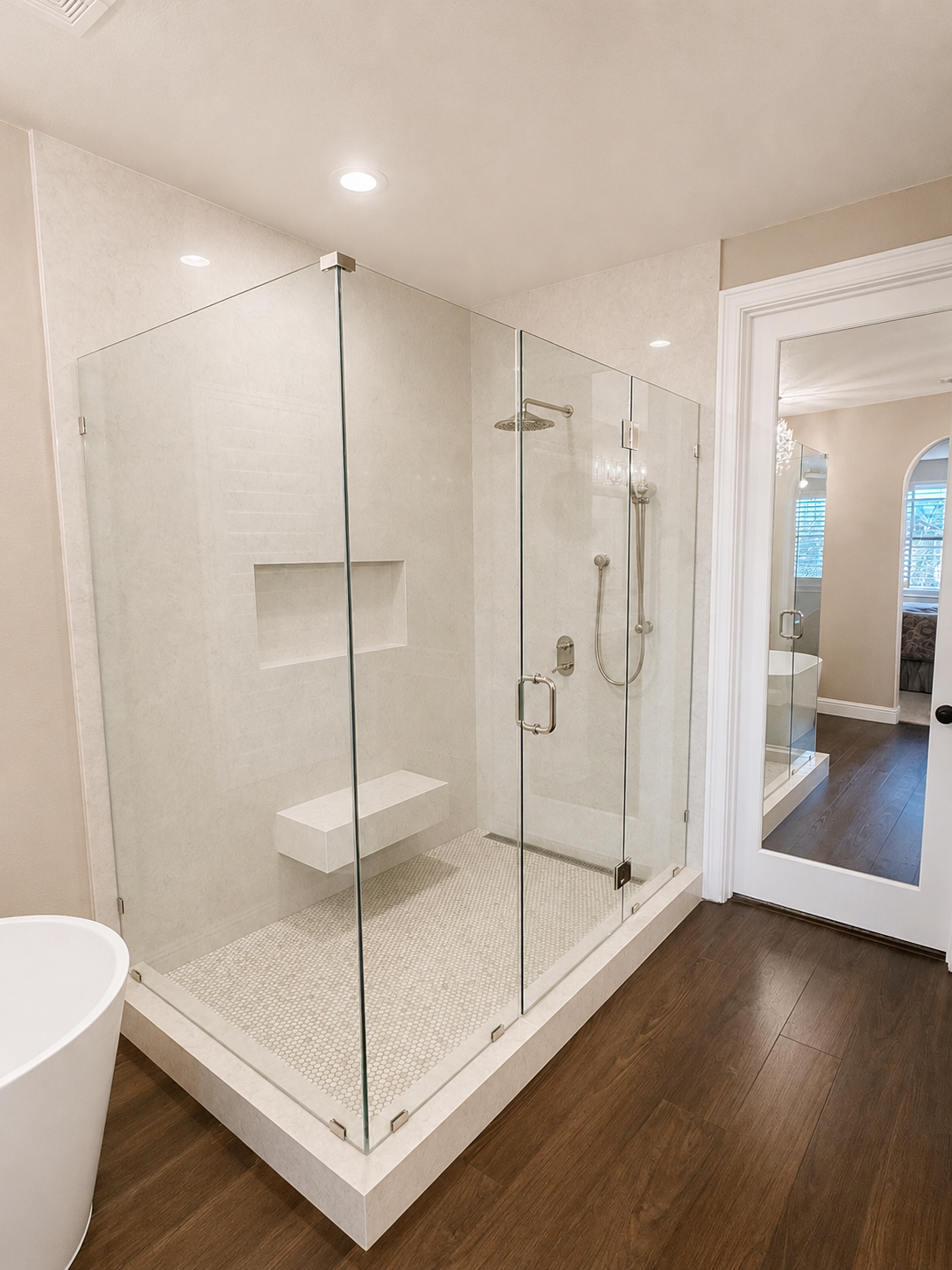 Modern bathroom with glass-enclosed shower, white tile, and dark wood flooring