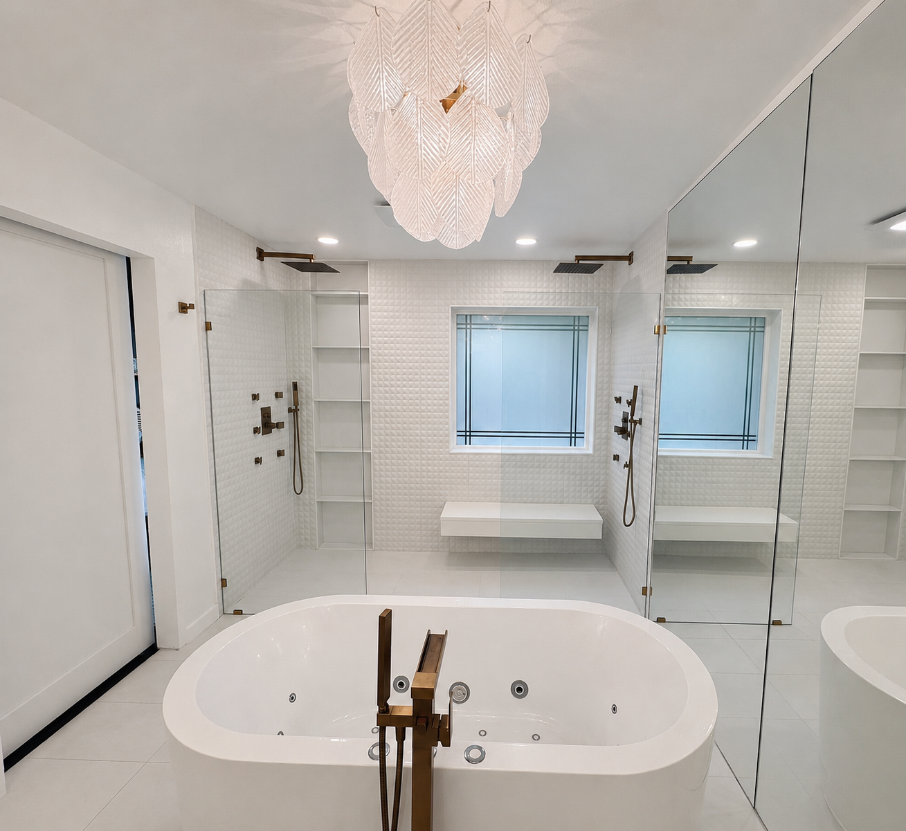 Modern white bathroom with freestanding tub, mirrored wall, windows, and crystal chandelier