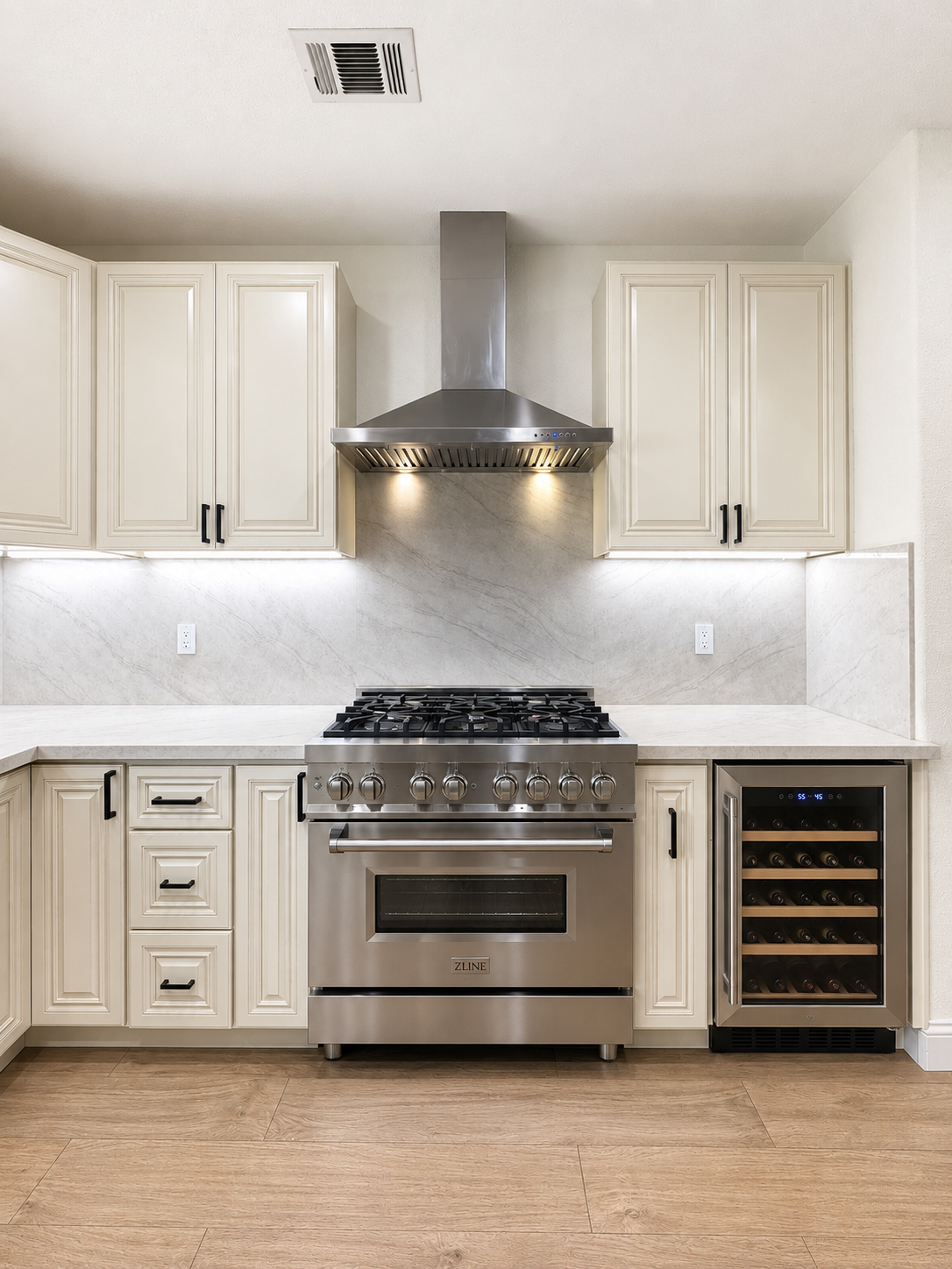Modern kitchen with white cabinets, stainless steel range and hood, and a built-in wine rack