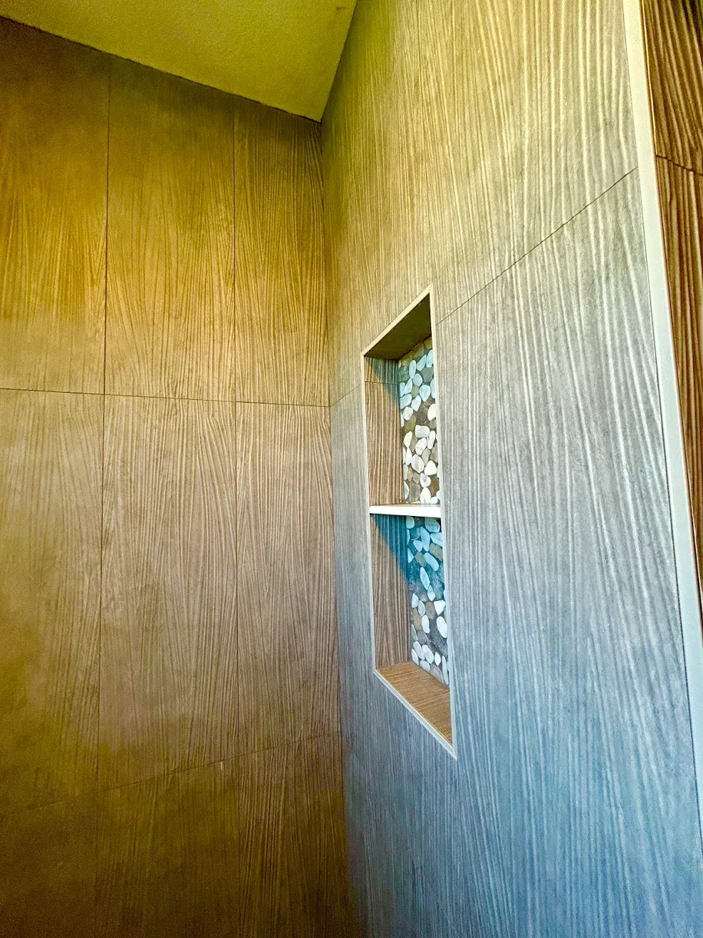 Interior corner with wood-paneled wall, textured light wall, and a small rectangular window