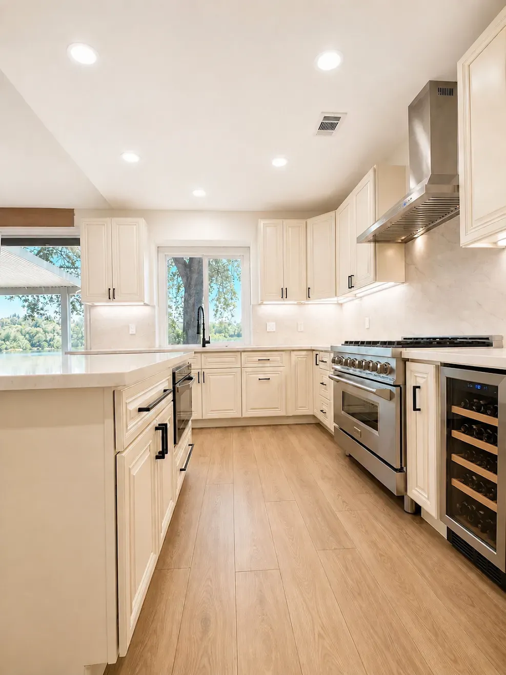 Bright modern kitchen with white cabinets, stainless steel appliances, and wood flooring