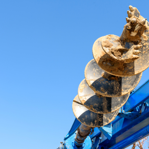 A close up of a drill bit with a blue sky in the background