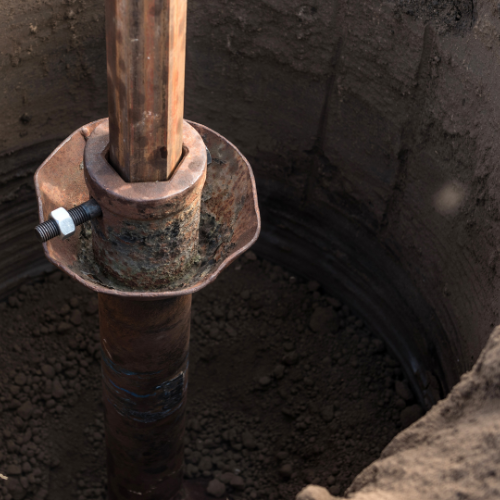 A close up of a metal pole in a hole
