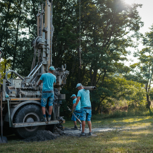 A group of men are working on a drilling rig in a field.