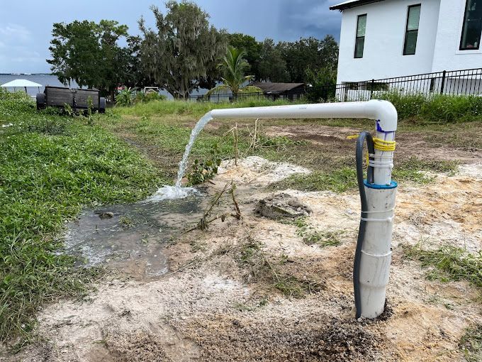Water is coming out of a pipe in a field.