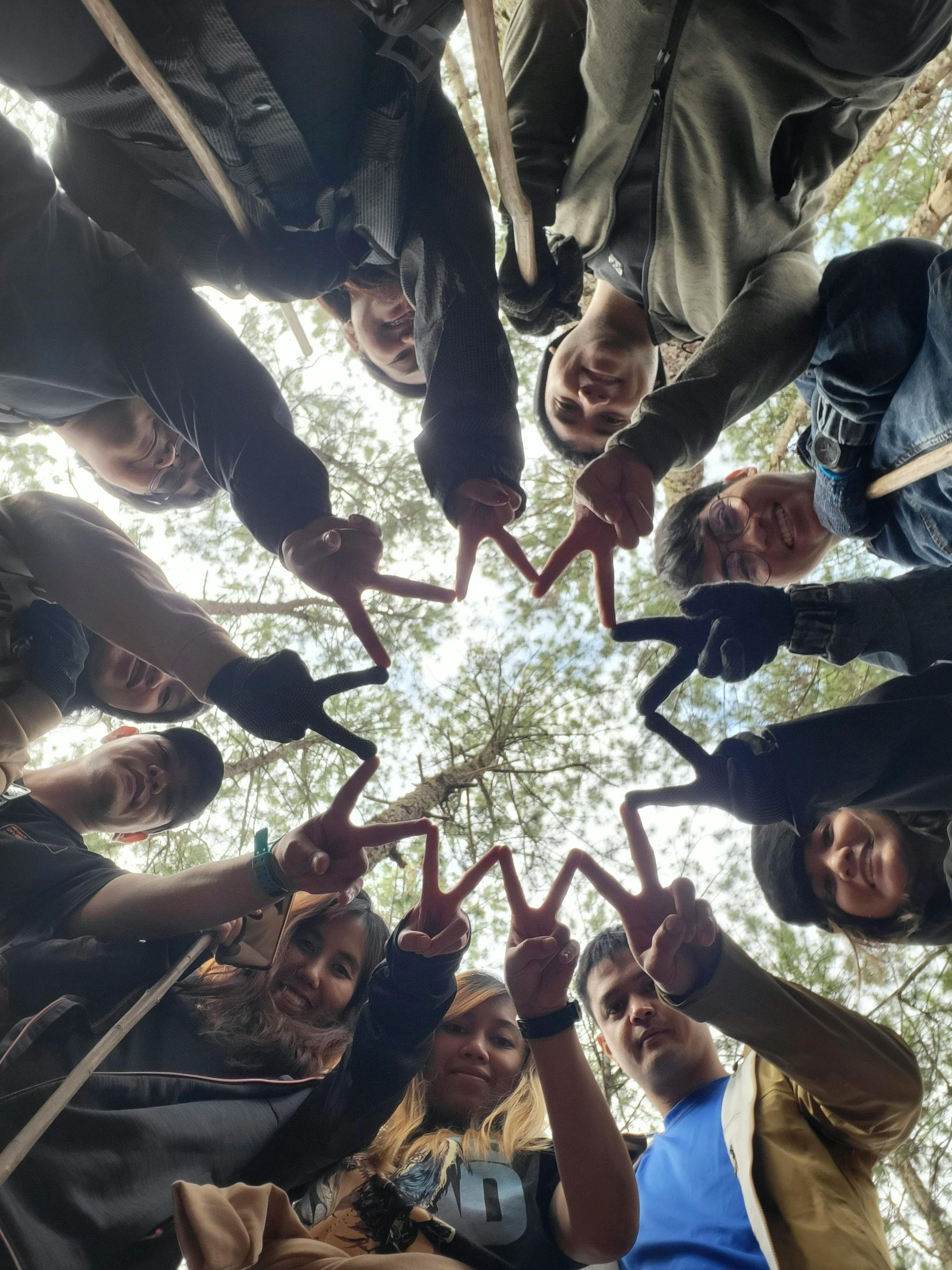 Des personnes forment une étoile avec leurs mains. À l'extérieur, le regard tourné vers le ciel.