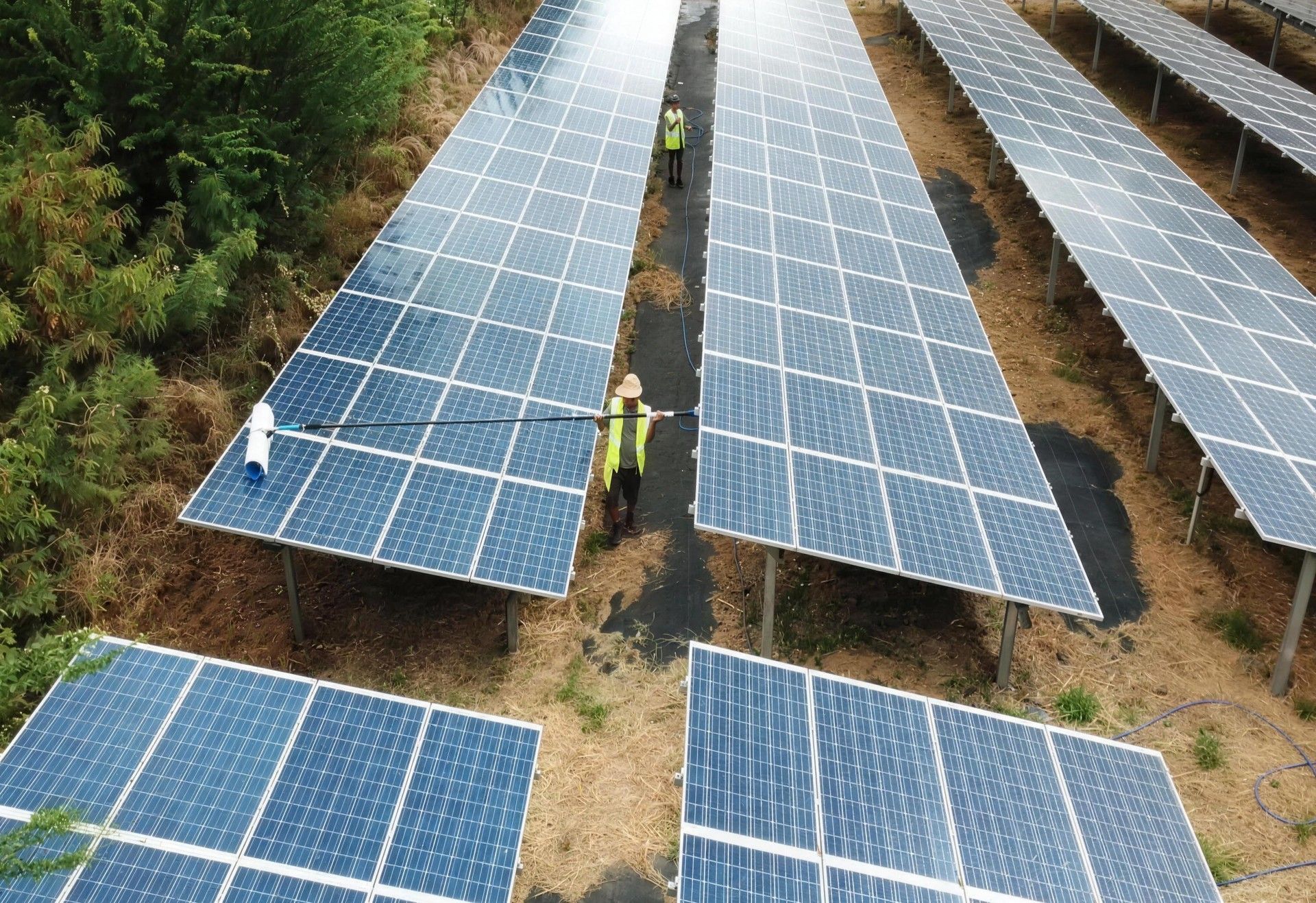 Aerial view of solar farm rows on Oahu with the crew between them