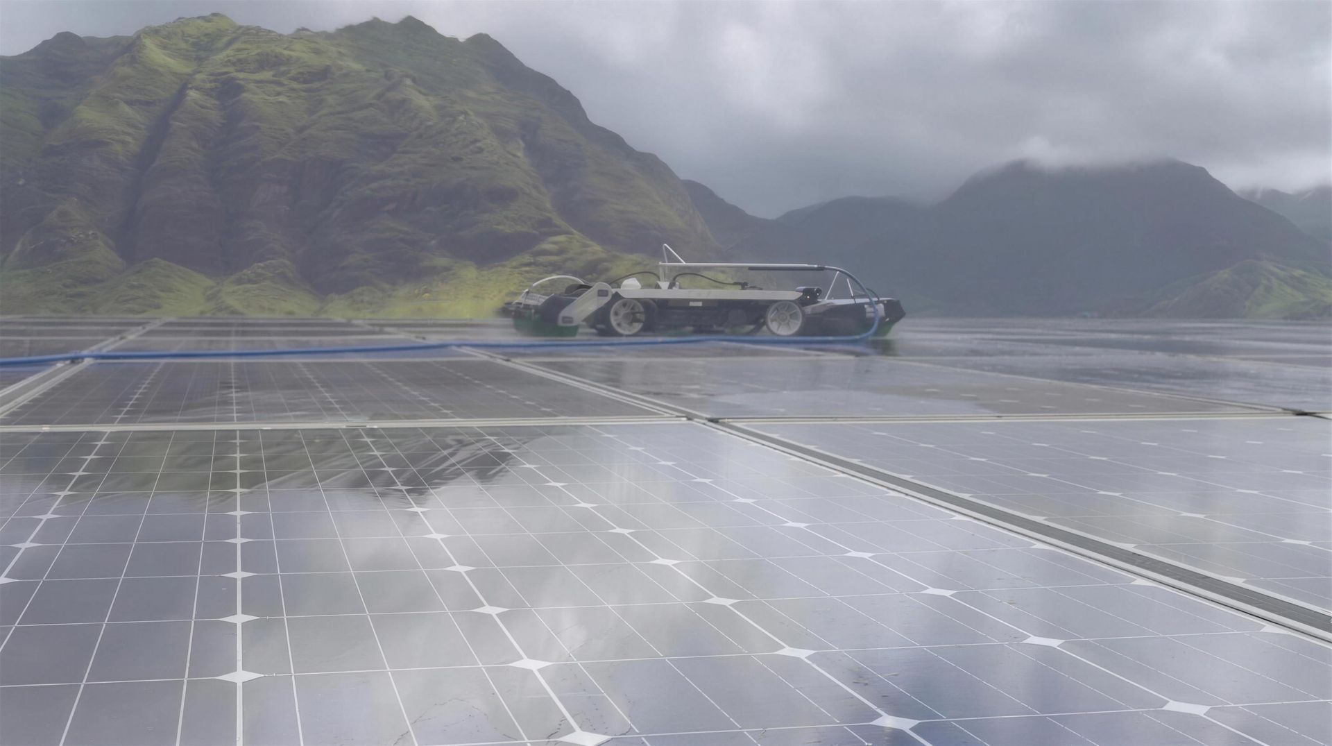 The cleaning robot on the rows of a solar farm, mountains behind
