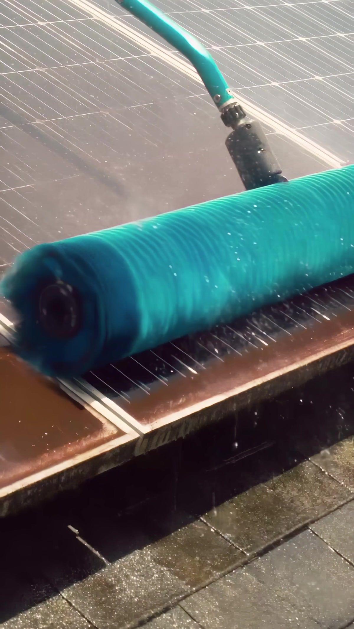 The rotating brush head on a solar panel, water pouring out of the bristles