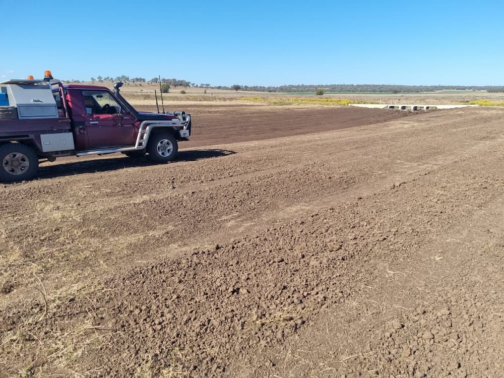 A Red Truck is Parked in a Dirt Field — Oakleigh Earthmoving in Cotswold Hills, QLD