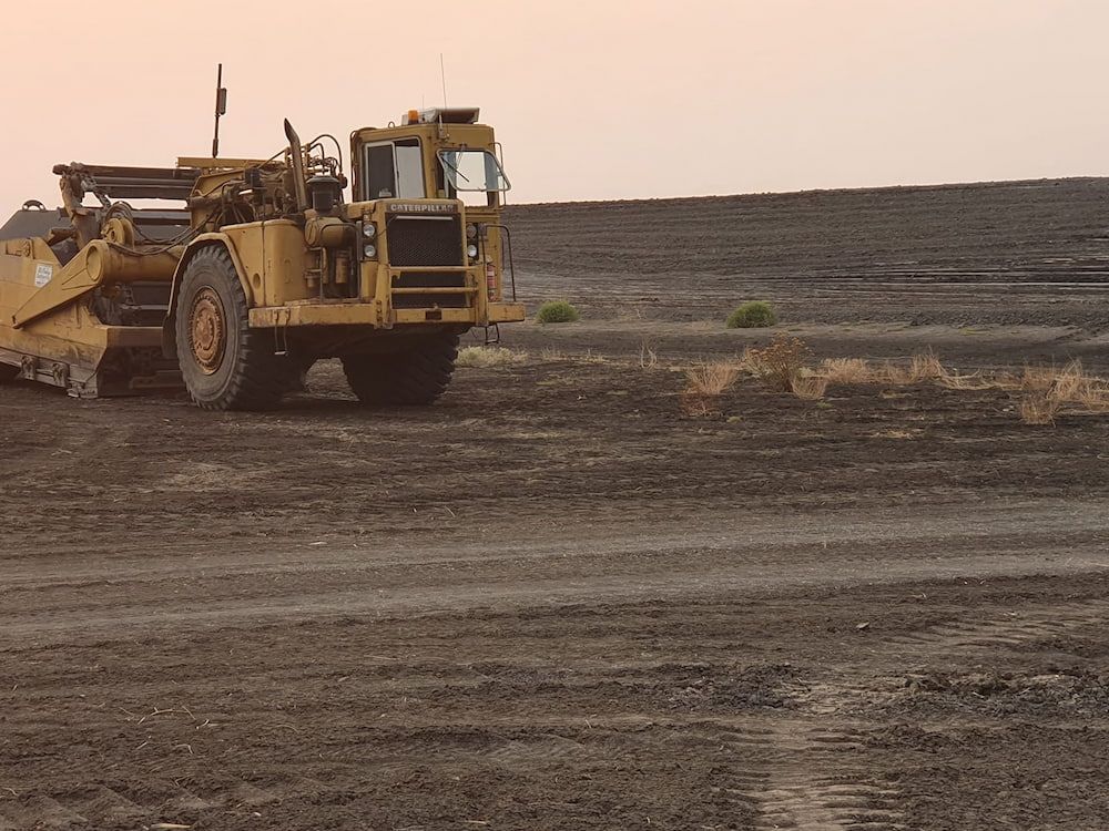 A Bulldozer is Driving Through a Dirt Field — Oakleigh Earthmoving in Warwick, QLD