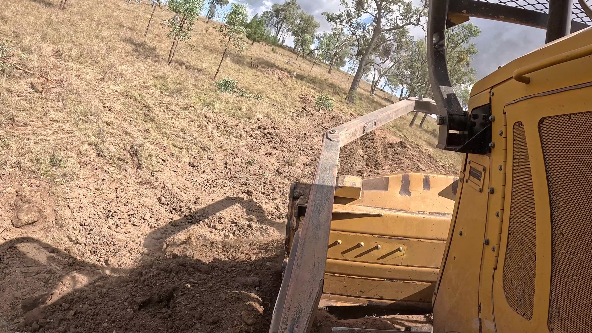 Yellow Excavator Working on a Dirt Hillside, Bucket Near the Ground — Oakleigh Earthmoving in Chinchilla, QLD