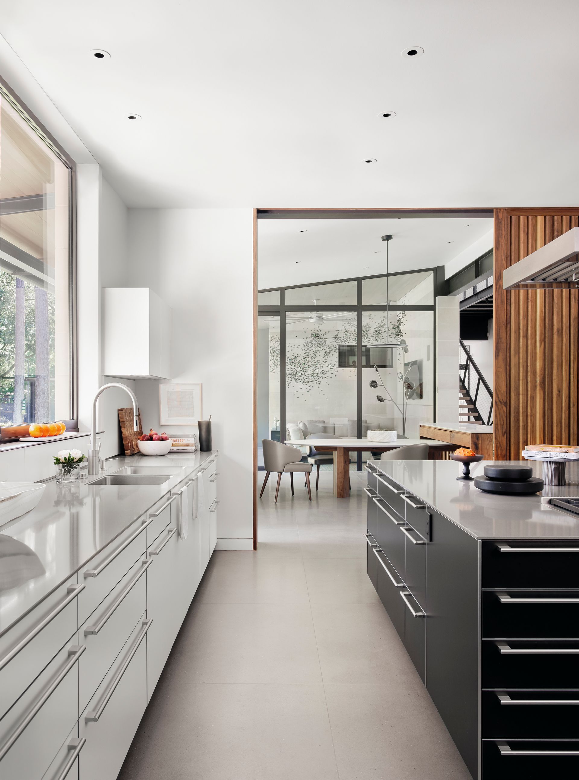 a kitchen with white cabinets and black drawers and a large island .