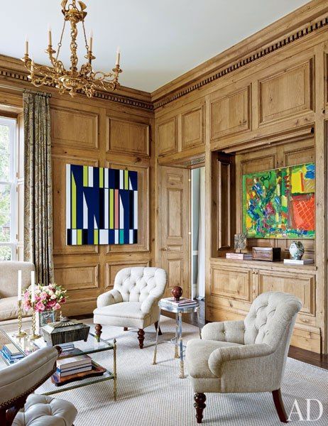 a living room with chairs and a painting on the wall