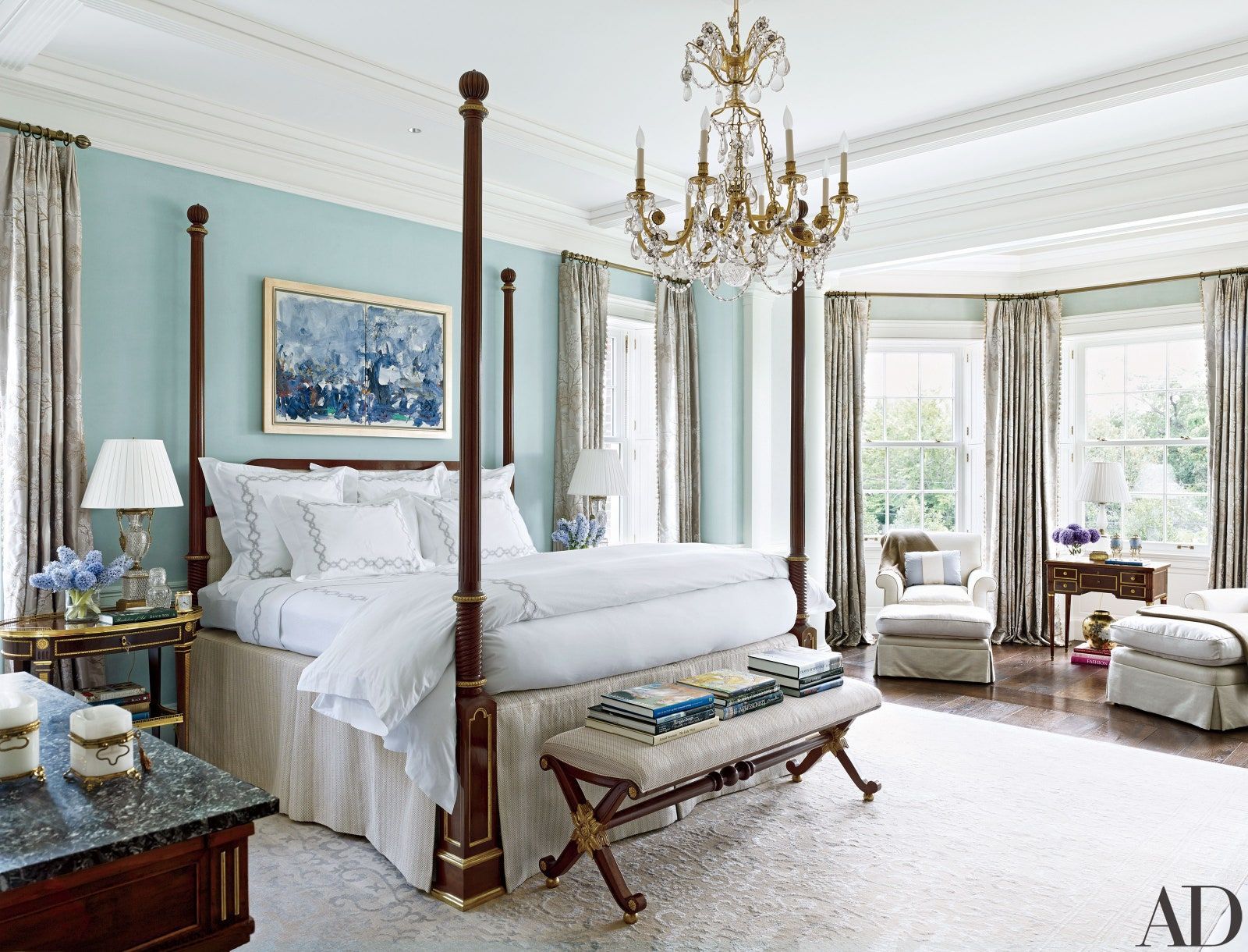 a bedroom with a four poster bed and a chandelier .