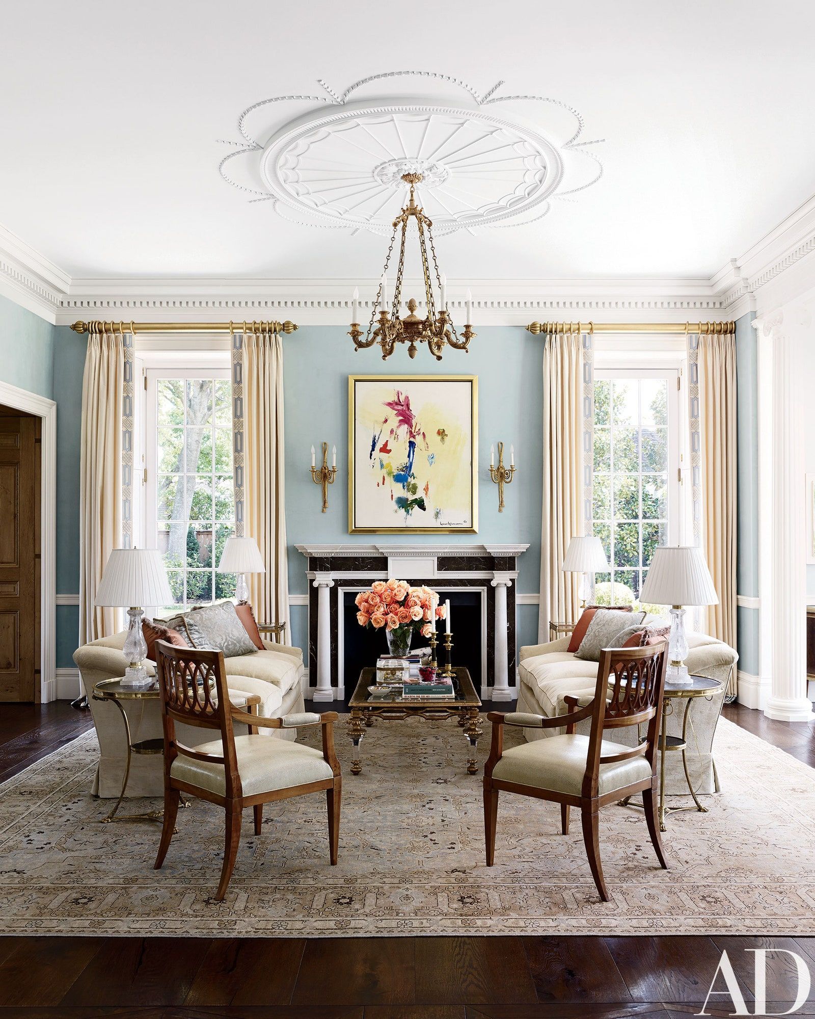 a living room with a fireplace and a painting on the wall