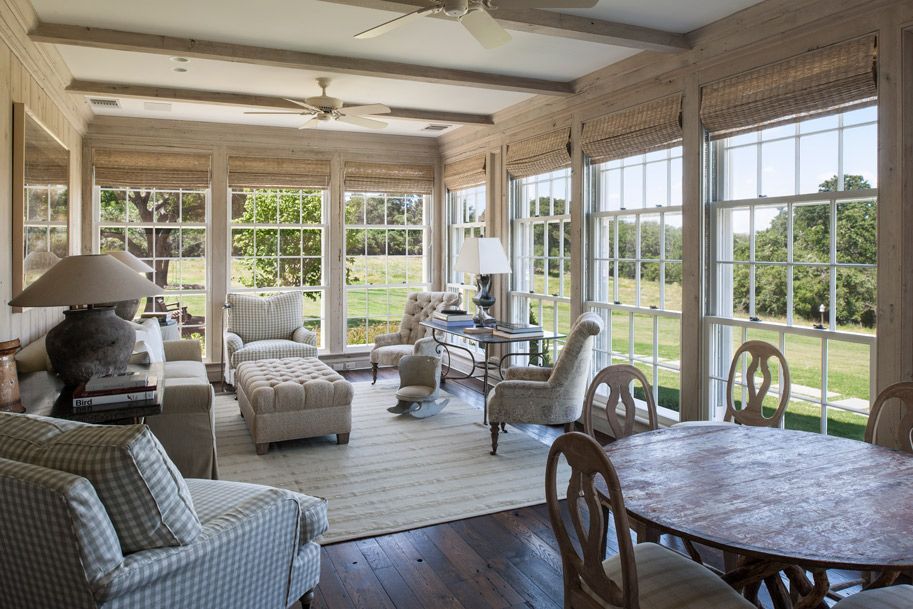 a living room with a table and chairs and a lot of windows