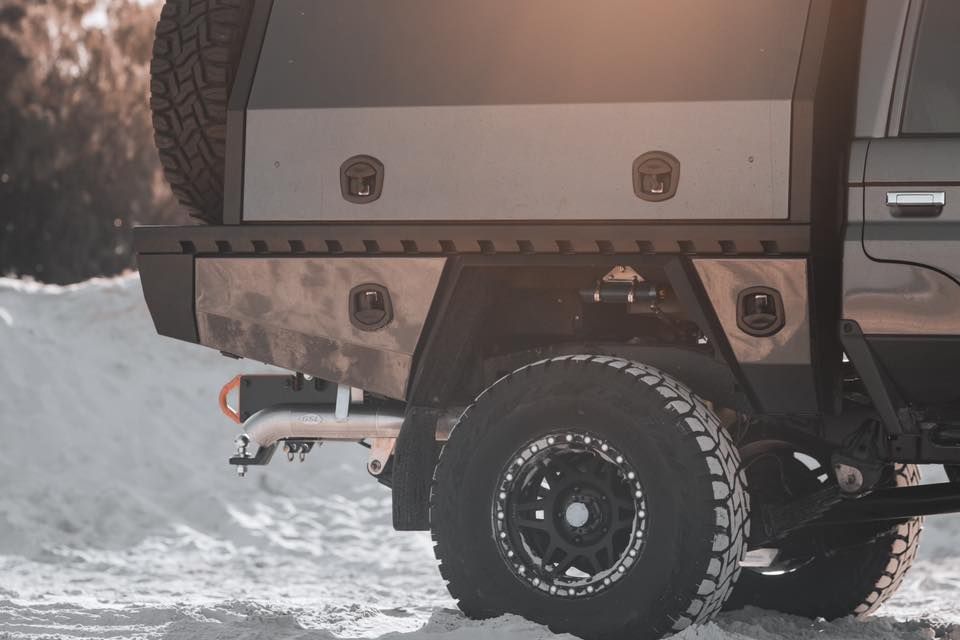 A Customized Pickup Truck With a Metal Tray Bed and Off-road Tires in a Snowy Setting — Custom RV Creations in Sumner, QLD