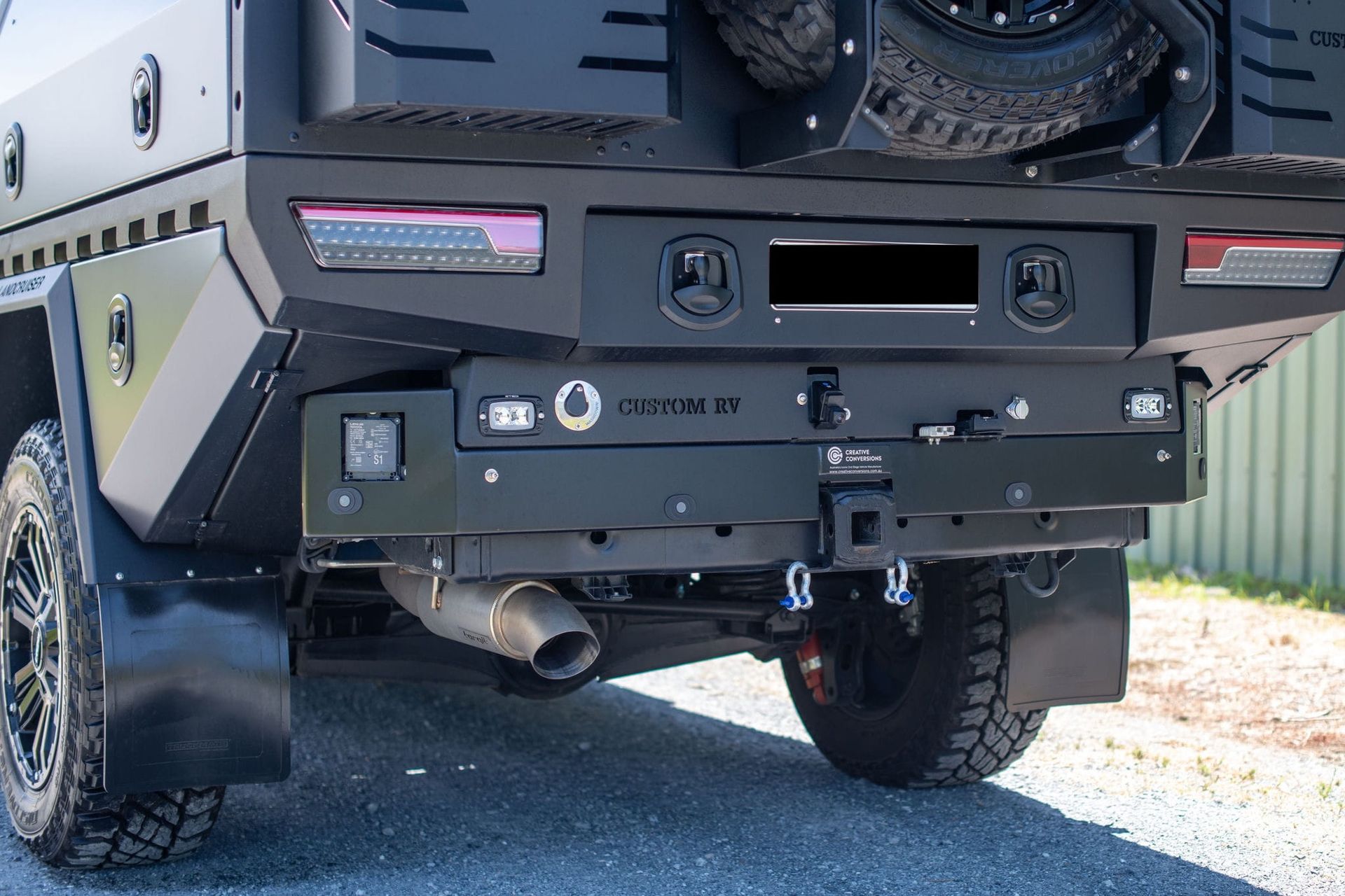 Rear of a Black Truck With a Custom Bumper, Spare Tire, and Towing Accessories — Custom RV Creations in Sumner, QLD