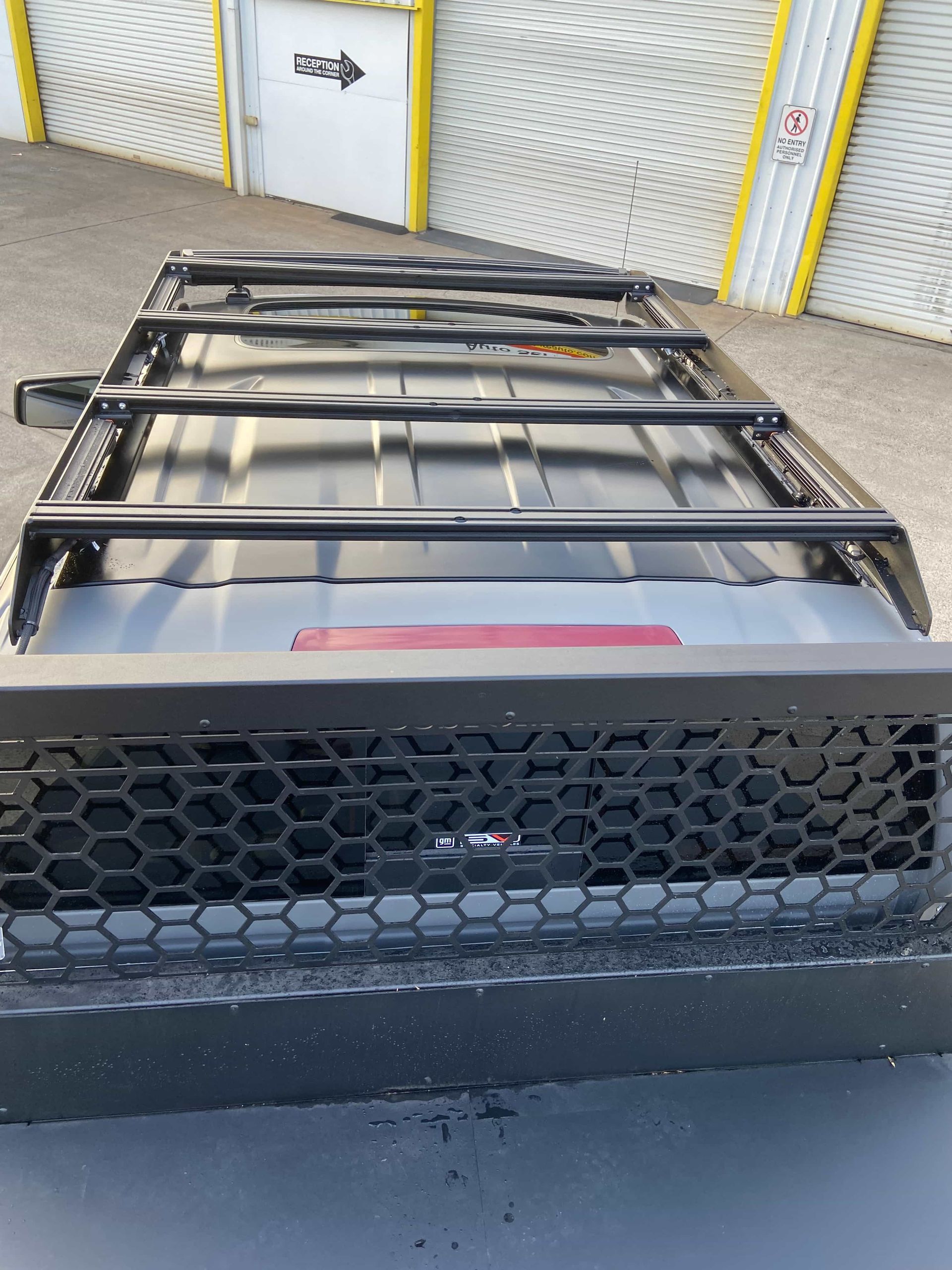 Black Roof Rack and Grill on a Vehicle. Black Cargo Rack Mounted on a Vehicle Roof, With a Protective Grill at the Rear — Custom RV Creations in Sumner, QLD