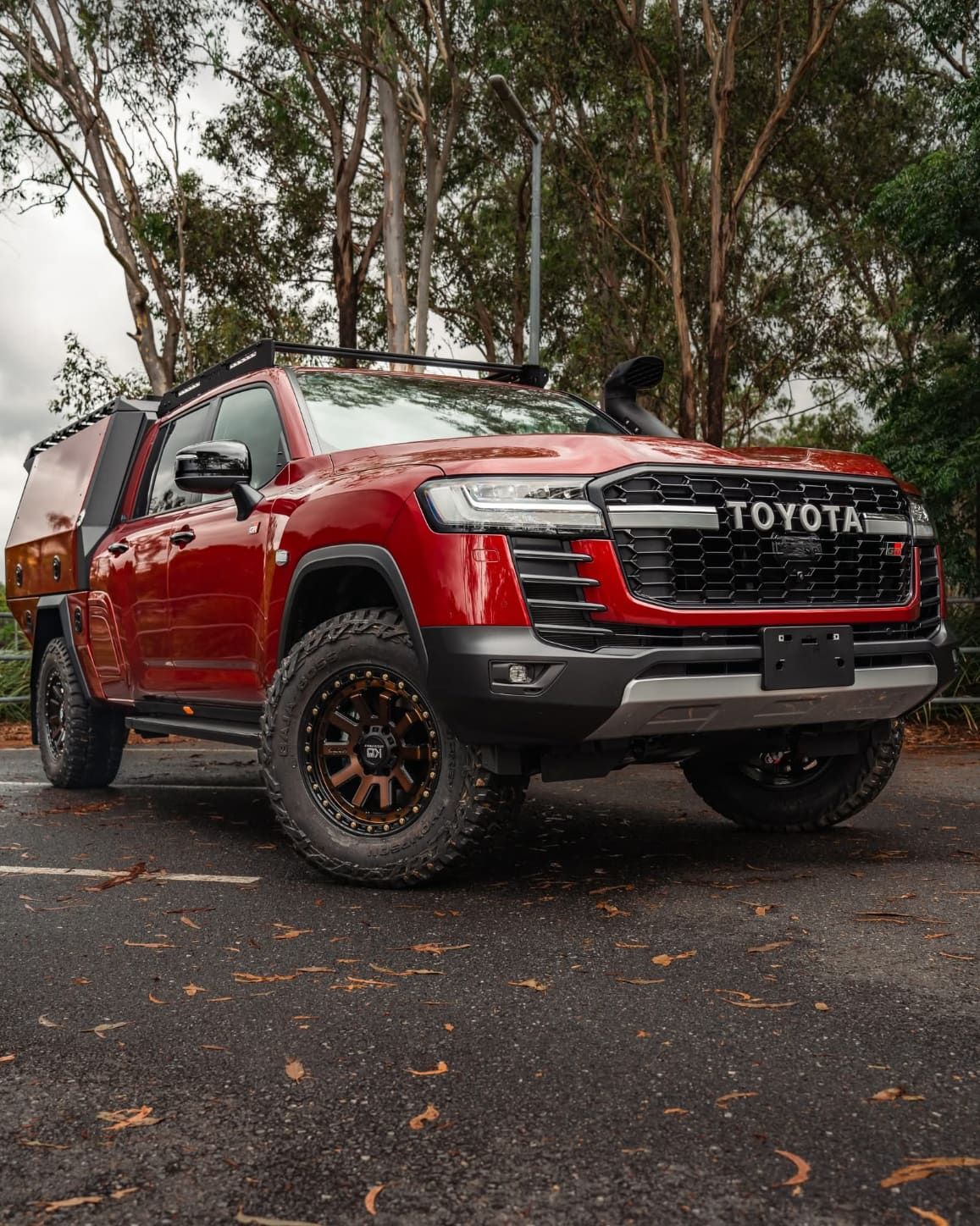 Red Toyota Land Cruiser With Off-road Modifications Parked on Asphalt — Custom RV Creations in Sumner, QLD