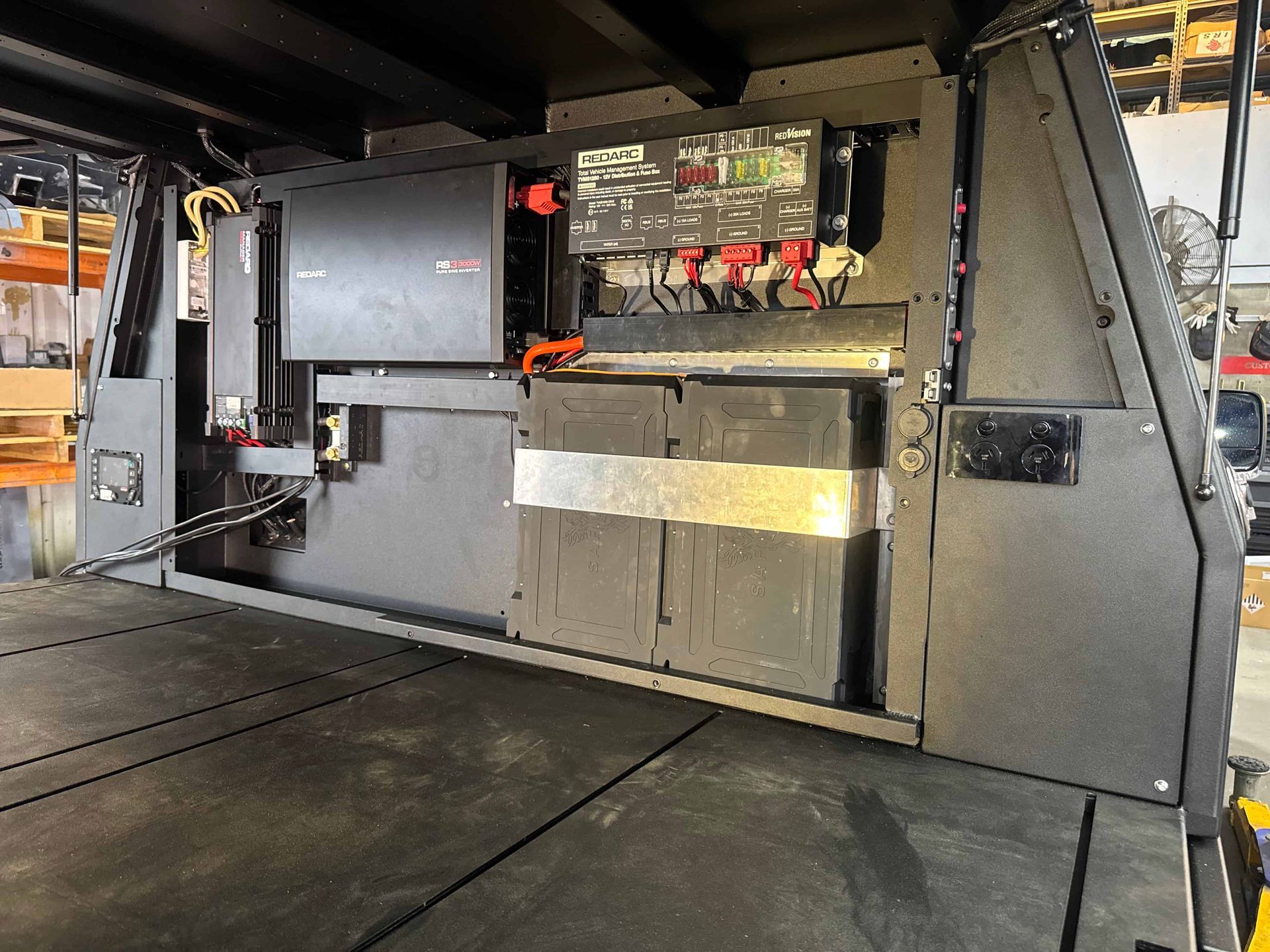 Black Camper Interior With Electrical Components and Storage Compartments — Custom RV Creations in Sumner Park, QLD