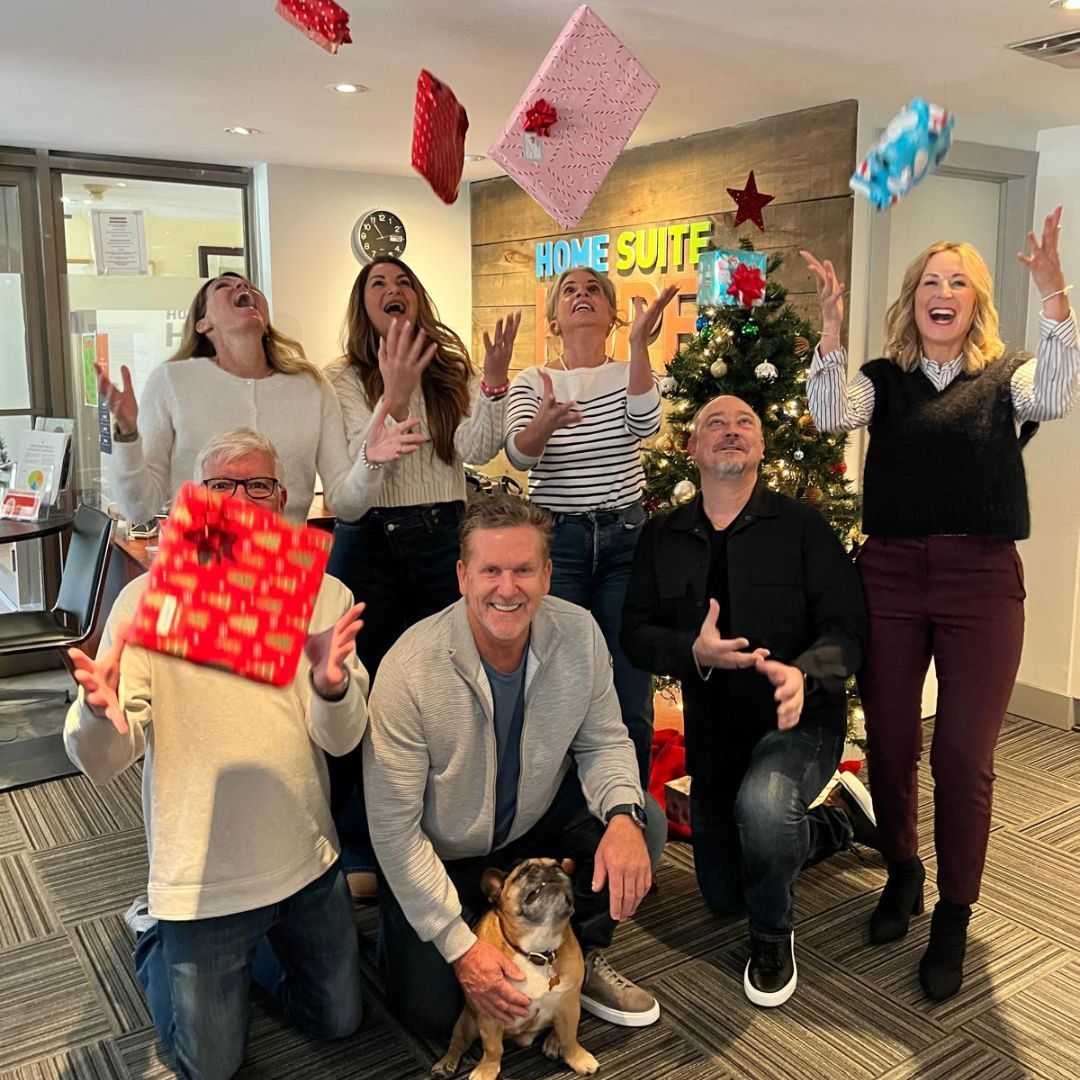 A group of people are posing for a picture in front of a christmas tree.