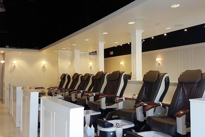 A row of chairs are lined up in a nail salon.