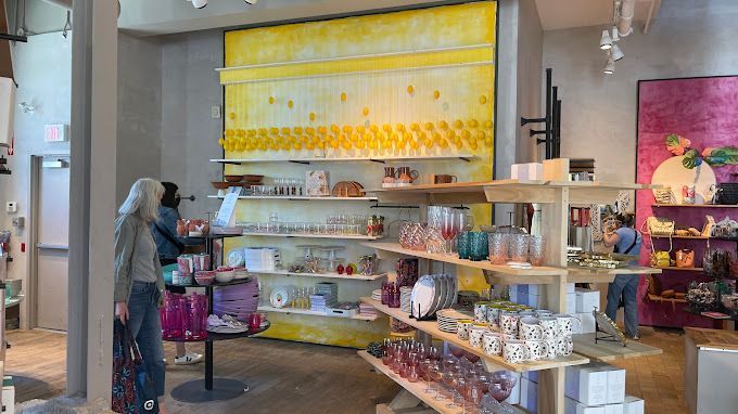 A woman is shopping in a store with lots of shelves.