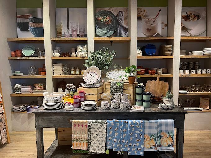 A table in a store filled with dishes and towels.