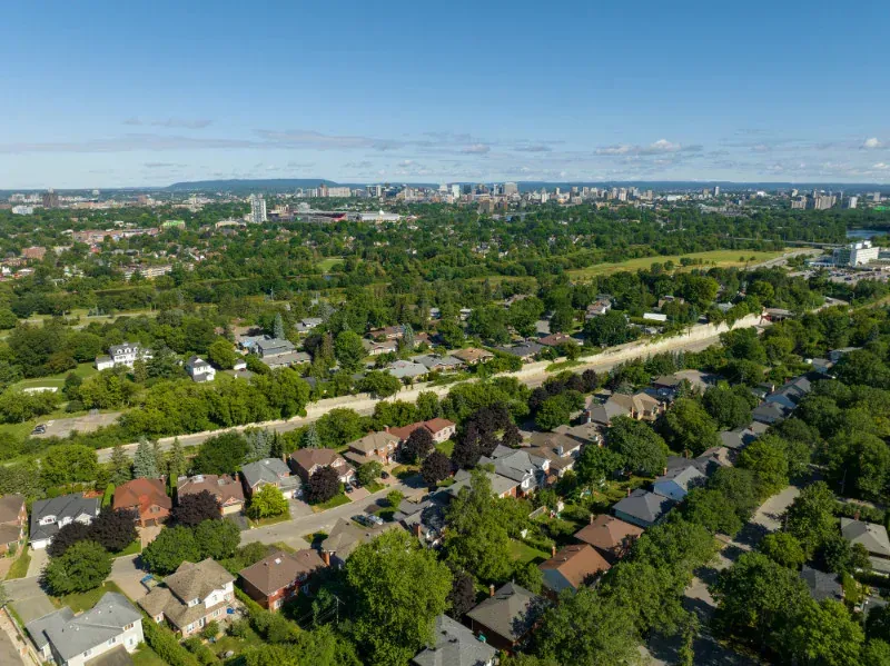 An aerial view of a residential area with a city in the background.