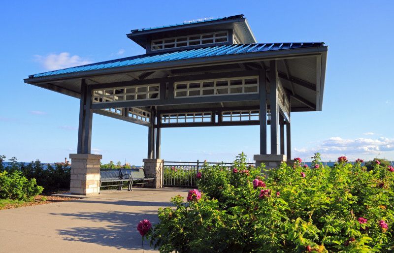A gazebo with a blue roof is surrounded by flowers in Mississauga, Ontario.